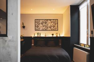 a bedroom with a bed with a black headboard at LOVE ROOM, La Douce Angevine in Angers