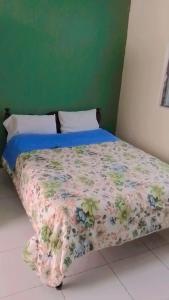 a bedroom with a bed with a floral comforter at HOTEL OASIS DOS MAX in Ipiales