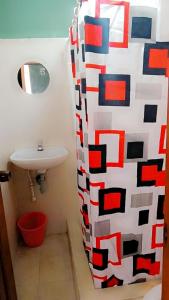 a bathroom with a shower curtain with a sink at HOTEL OASIS DOS MAX in Ipiales