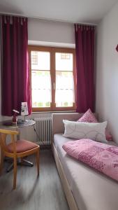 1 dormitorio con cama, mesa y ventanas en Schwabenstuben Einzelzimmer, en Meersburg