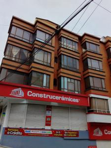 a red brick building with a sign on it at HOTEL OASIS DOS MAX in Ipiales