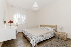 ein weißes Schlafzimmer mit einem Bett und einem Fenster in der Unterkunft Apartments Katarina in Ðenovići