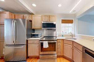 a kitchen with stainless steel appliances and wooden cabinets at Town of Rehoboth Beach - 50A Olive Ave in Rehoboth Beach