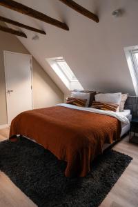 ein Schlafzimmer mit einem großen Bett im Dachgeschoss in der Unterkunft Pieks Noordlaren in Noordlaren