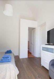 ein Wohnzimmer mit einem Bett und einem TV in der Unterkunft Casa del Contrabbasso in Palermo