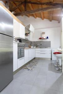 eine Küche mit weißen Schränken und einem Kühlschrank aus Edelstahl in der Unterkunft Casa del Contrabbasso in Palermo