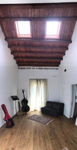 ein Wohnzimmer mit einem Sofa und 2 Fenstern in der Unterkunft Casa del Contrabbasso in Palermo