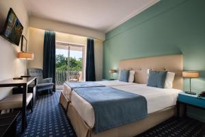 um quarto de hotel com uma cama, uma escrivaninha e uma janela em Grão Vasco - Historic Hotel and SPA em Viseu mais 37 fotografias