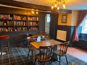 a dining room with a table and chairs and bookshelves at The George Inn at Tideswell in Tideswell
