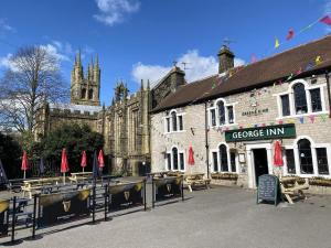 a building with a dmg inn in front of a cathedral at The George Inn at Tideswell in Tideswell