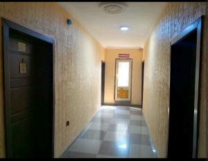 an empty hallway with a door and a tile floor at Hibis k hotel (green gate) in Lagos