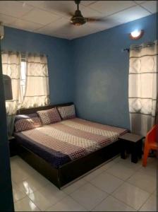 a bed in a room with a blue wall at Hibis k hotel (green gate) in Lagos