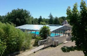 ein großes Gebäude mit einem Pool davor in der Unterkunft Mobil-home le petit paradis camping 3 étoiles à 7km des plages in Avrillé