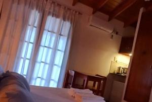 a bedroom with a bed and a large window at Palmeras Appart Hotel in Chascomús