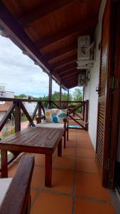a porch with a wooden table and benches on a building at Palmeras Appart Hotel in Chascomús