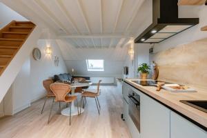 a kitchen and dining room with a table and chairs at Bright apartment close to the sea in Ostend