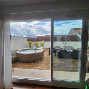 a large patio with a hot tub on a deck at Magnifique logement spa in Pau