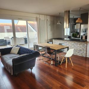 een woonkamer met een bank en een tafel met stoelen bij Magnifique logement spa in Pau