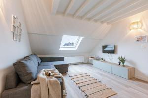 uma sala de estar com um sofá e uma televisão em Bright apartment close to the sea em Ostend