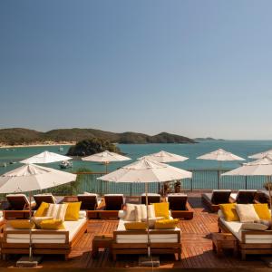 um monte de cadeiras e guarda-sóis num deque em Casas Brancas Boutique Hotel & Spa em Búzios