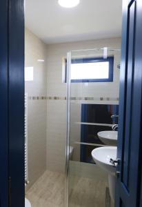 uma casa de banho com uma cabina de duche em vidro e um lavatório. em PRIVET em Jurilovca