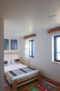 una camera con un letto in una stanza con finestre di PRIVET a Jurilovca