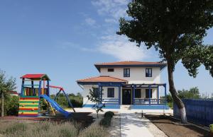 uma casa com escorrega e um parque infantil em PRIVET em Jurilovca