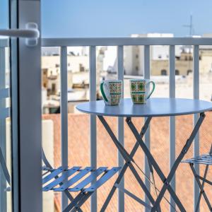 - deux tasses à café assises sur une table sur un balcon dans l'établissement Ta Cetta Apartment 5 min walk from St Julians, à San Ġwann