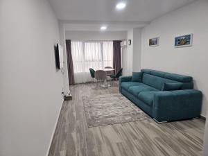 a living room with a green couch and a table at Sea View Apartments Olimp Etajul 9 in Olimp