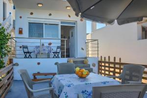 a table with a bowl of fruit on a patio at La mer stegna in Archangelos