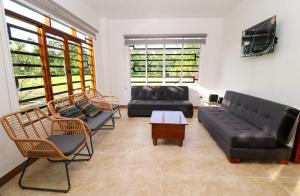 ein Wohnzimmer mit 2 Sofas, einem Tisch und Stühlen in der Unterkunft PARADISE LODGE in Tena