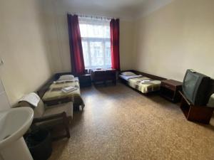 a room with two beds and a tv in it at Hostel Viktorija with Private Rooms in Rīga