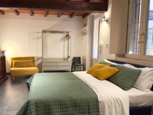 克雷莫納的住宿－Violino green，一间卧室配有一张大床和一张黄色椅子