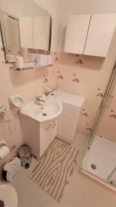 Baño blanco con lavabo y espejo en Appartamento Oasi Zegna en Bielmonte
