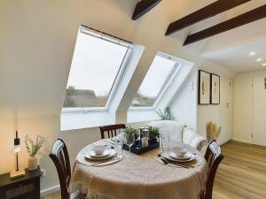 een eetkamer met een tafel en twee ramen bij Apartment in Leverkusen Waldsiedlung in Leverkusen