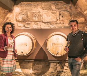a man and a woman standing in front of three wine barrels at Teatrisso Hotel Palacio in Cuzcurrita-Río Tirón +110 photos