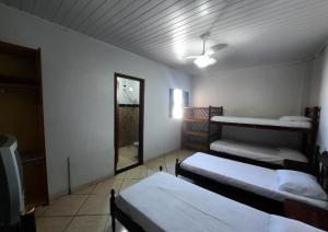 a room with three beds and a ceiling fan at Hotel Presidente - By UP Hotel in Campo Mourão