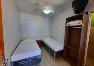 a small room with two beds and a ceiling fan at Hotel Presidente - By UP Hotel in Campo Mourão