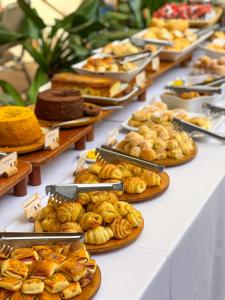 a table with many different types of pastries and cakes at Castro's Park Hotel in Goiânia