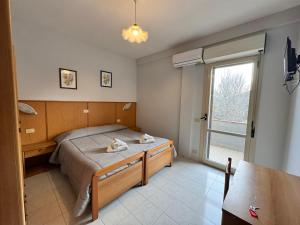1 dormitorio con cama y ventana grande en Da Bosio en Genga