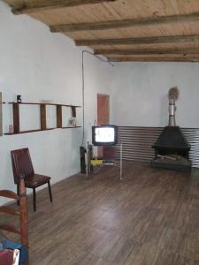 ein Wohnzimmer mit Fernseher, Sofa und Sessel in der Unterkunft LuSil in El Nihuil