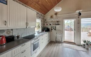 cocina con armarios blancos y techo de madera en Nice Home In Jelsa With Kitchen en Jelsa