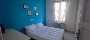 Sofá blanco en habitación azul con ventana en BiblioSosta anche al 1° Piano anno 2024, en Ventimiglia
