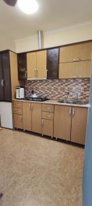 a large kitchen with wooden cabinets and a sink at Pink house in Lankaran