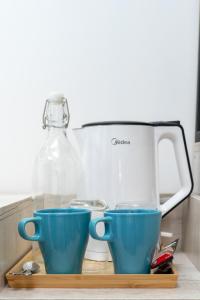 two blue cups on a cutting board next to a juicer at Ukulhas Sands in Ukulhas