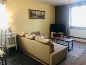 a living room with a couch and a television at Newly renovated Old bakery House in Bath, 3 Bedroom, FREE Parking in Bath