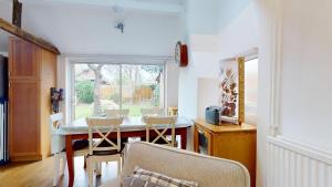 een eetkamer met een tafel en stoelen en een raam bij Orchard Cottage in Oxford