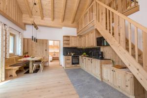 a large kitchen with wooden cabinets and a staircase at Bäckerhof in Tesido