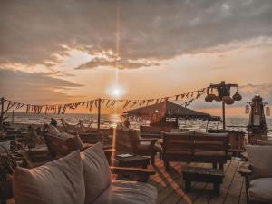 uma vista para uma praia com cadeiras e um pôr-do-sol em Vacanzamare em Wenduine