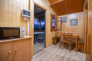 a kitchen with a microwave and a table in a cabin at Camping Ria de Arosa 1 in A Pobra do Caramiñal